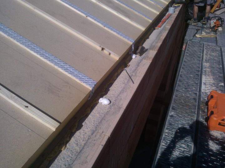 Toiture en cours d’isolation avec panneaux rigides fixés par bandes métalliques Mâcon